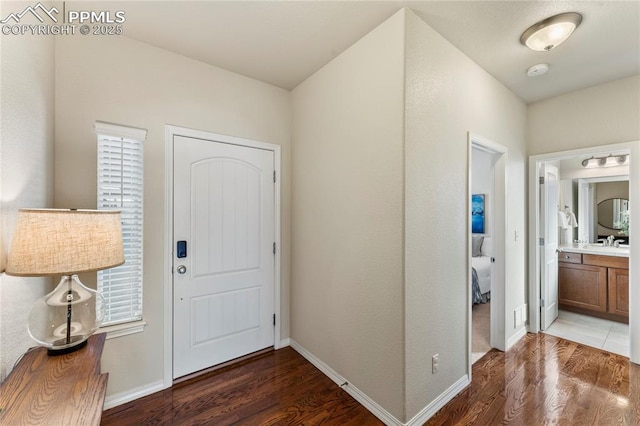 foyer featuring baseboards and wood finished floors