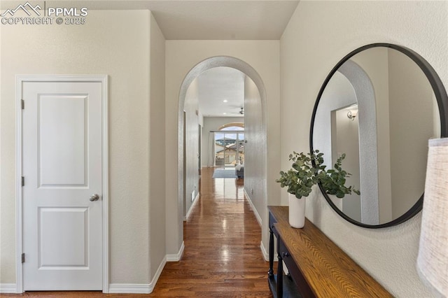 corridor with baseboards and wood finished floors