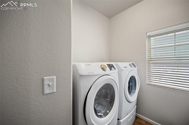 washroom featuring baseboards, a wealth of natural light, laundry area, and independent washer and dryer