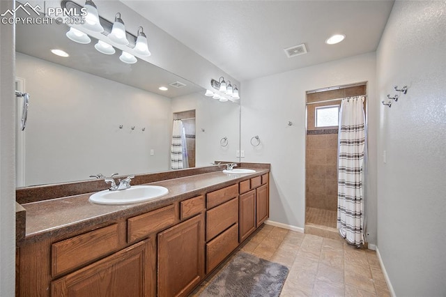 full bathroom featuring tiled shower, visible vents, a sink, and double vanity