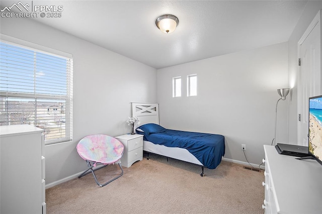 bedroom featuring light carpet and baseboards