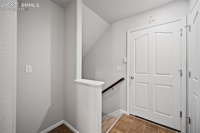doorway featuring tile patterned flooring and baseboards