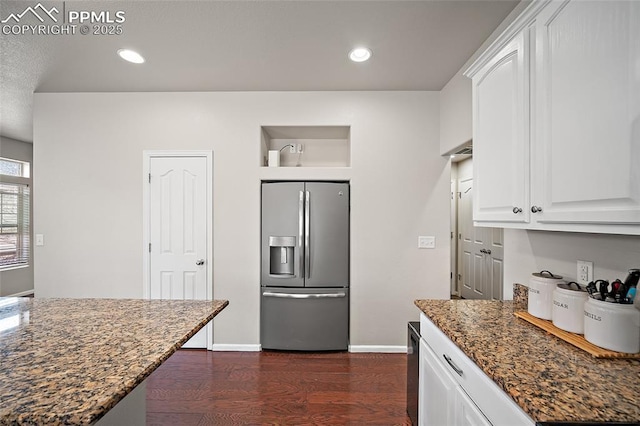 kitchen featuring dark stone countertops, stainless steel refrigerator with ice dispenser, white cabinetry, dark wood-style flooring, and recessed lighting