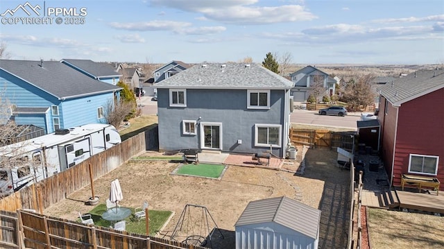 back of property with stucco siding, a deck, a fenced backyard, a residential view, and a patio area