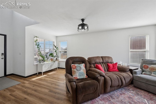 living area with baseboards and wood finished floors