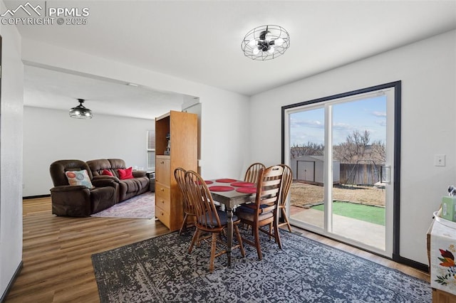 dining space with baseboards and wood finished floors