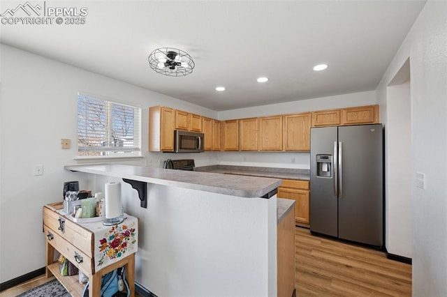 kitchen featuring light wood-style flooring, recessed lighting, stainless steel appliances, a peninsula, and light countertops