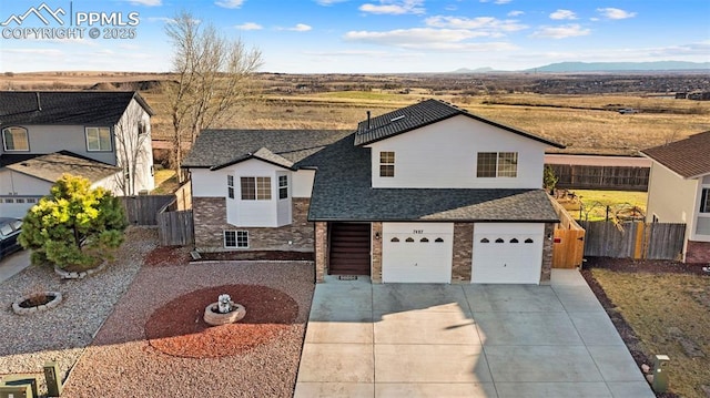 view of front of home with fence, concrete driveway, an attached garage, a shingled roof, and brick siding