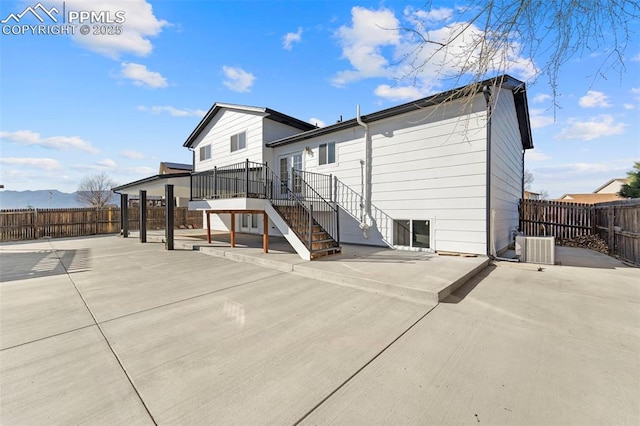 rear view of house with a patio area, stairway, cooling unit, and a fenced backyard