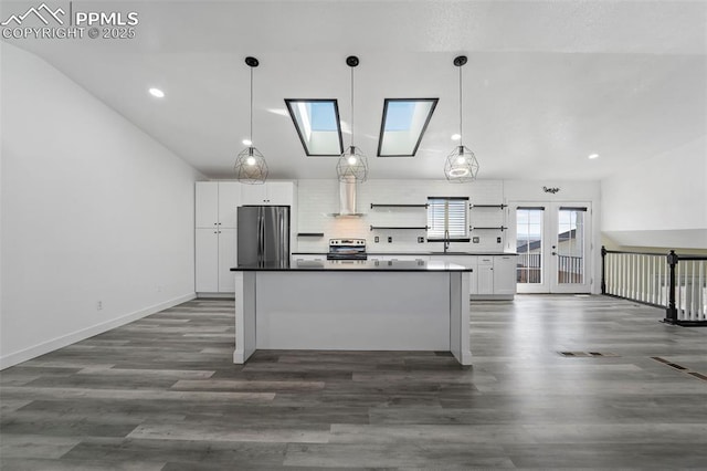 kitchen featuring stainless steel appliances, a kitchen island, dark wood-style floors, and white cabinets