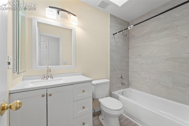 bathroom featuring visible vents, toilet, wood finished floors, shower / bath combination, and vanity