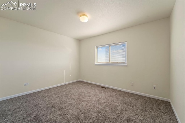 carpeted spare room featuring visible vents and baseboards