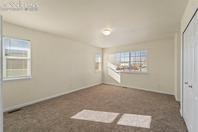 unfurnished bedroom featuring a closet, visible vents, baseboards, and carpet floors