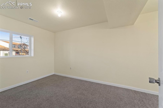 carpeted spare room with visible vents and baseboards