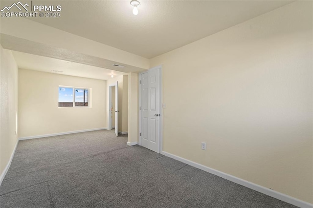 spare room featuring carpet and baseboards