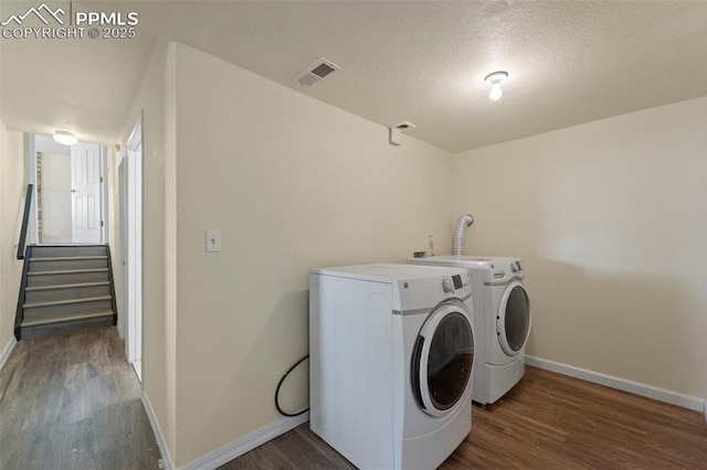 washroom with washer and dryer, visible vents, wood finished floors, and laundry area