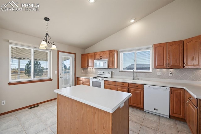 kitchen featuring visible vents, a healthy amount of sunlight, white appliances, and a sink