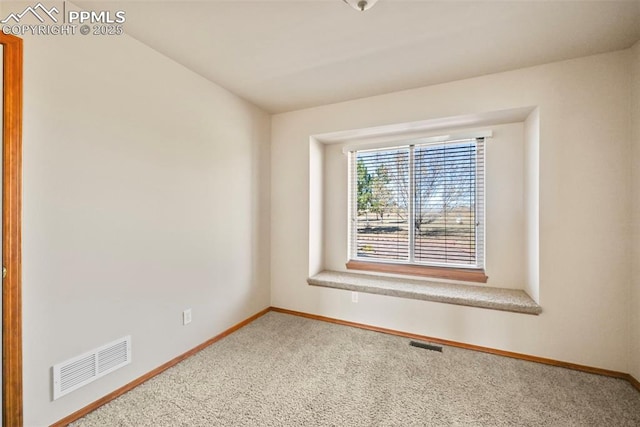 carpeted empty room featuring baseboards and visible vents