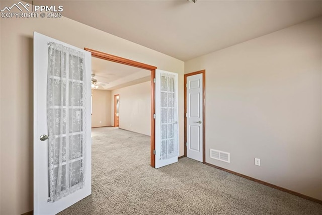 unfurnished room with visible vents, baseboards, and carpet