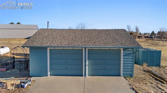 detached garage featuring fence