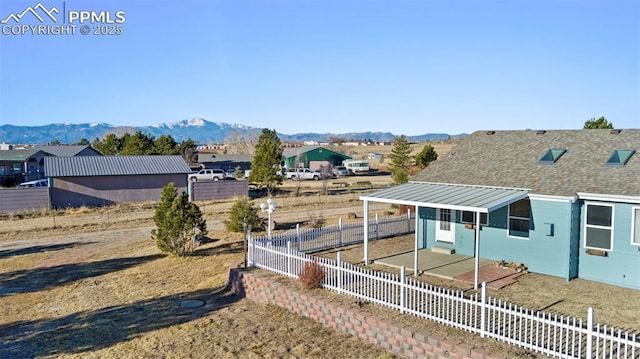 view of yard featuring a mountain view and fence