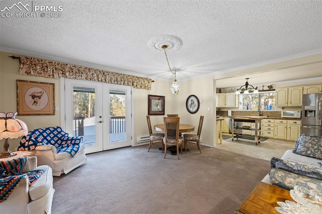 living room with an inviting chandelier, ornamental molding, french doors, a textured ceiling, and light colored carpet