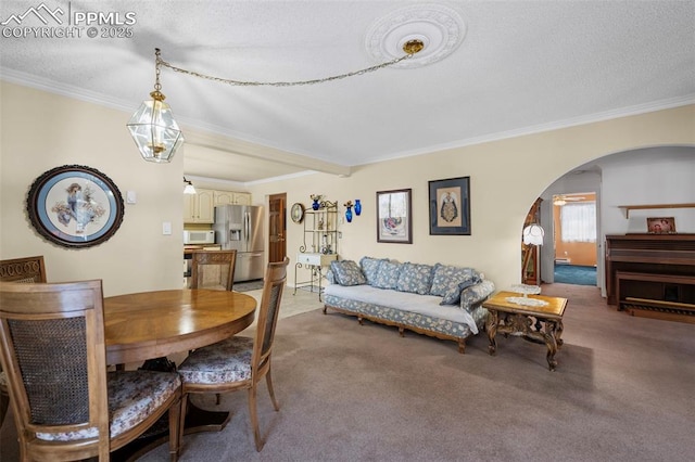 carpeted dining room featuring arched walkways, a textured ceiling, and crown molding