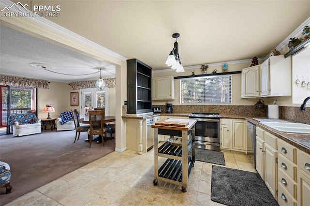 kitchen featuring open shelves, a sink, appliances with stainless steel finishes, light carpet, and cream cabinets