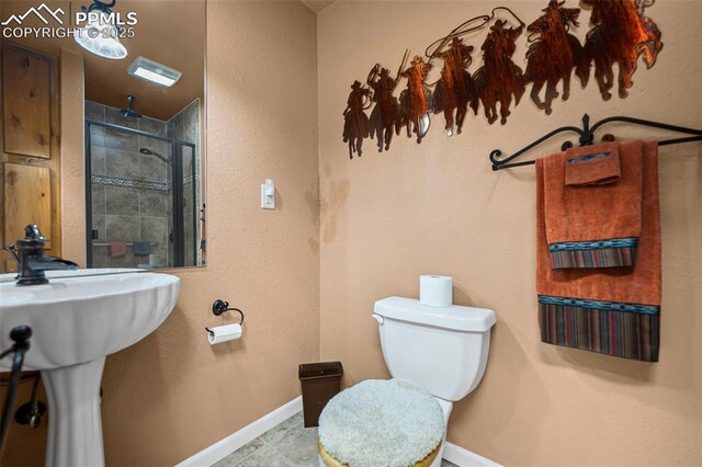 bathroom featuring toilet, baseboards, and tiled shower