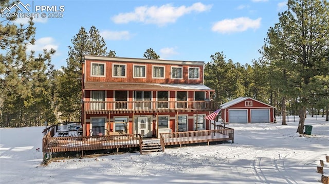 chalet / cabin featuring a deck, an outbuilding, and a garage