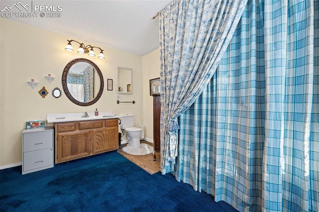 full bathroom with vanity, baseboards, a textured ceiling, curtained shower, and toilet