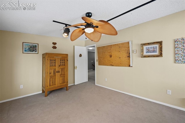 carpeted empty room featuring a textured ceiling, baseboards, and a ceiling fan