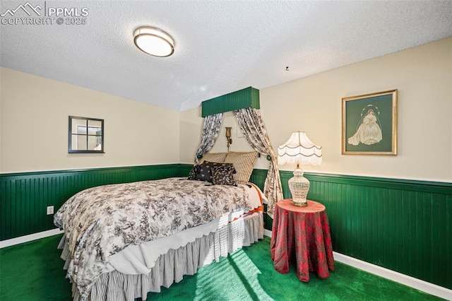 carpeted bedroom featuring a textured ceiling and wainscoting