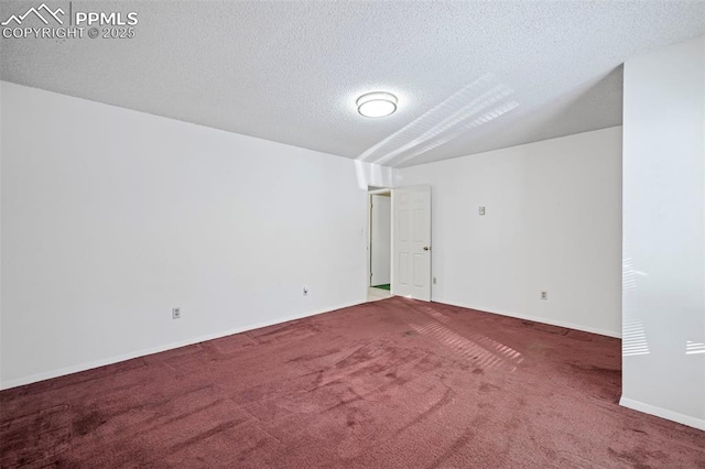 carpeted empty room with baseboards and a textured ceiling