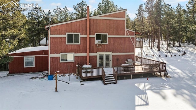 snow covered property with french doors and a deck