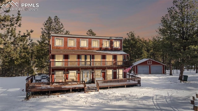 view of front of house with an outdoor structure, a detached garage, and a wooden deck