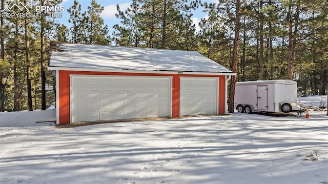 snow covered garage featuring a garage