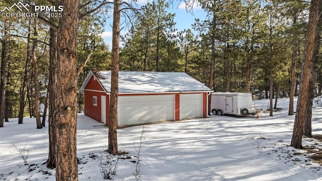 snow covered garage with a garage