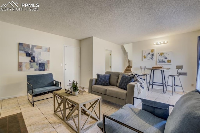 living room featuring light tile patterned flooring, stairway, a textured ceiling, and baseboards