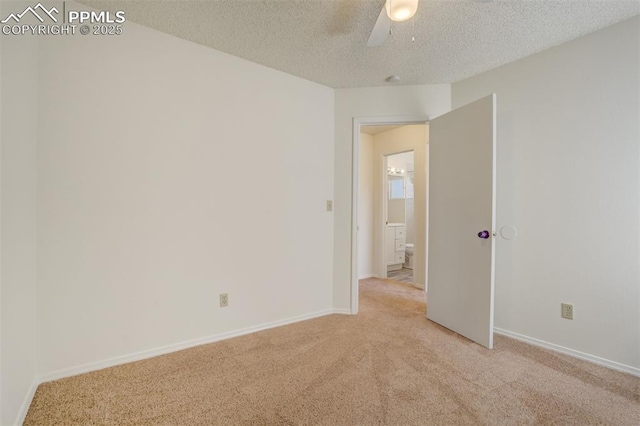 empty room featuring light carpet, ceiling fan, a textured ceiling, and baseboards