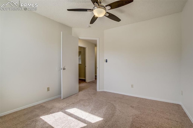 empty room featuring a textured ceiling, a ceiling fan, baseboards, and light carpet