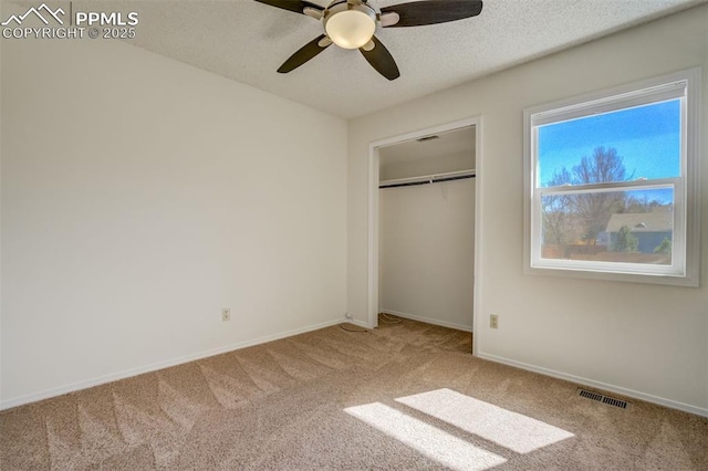 unfurnished bedroom featuring visible vents, a textured ceiling, a closet, carpet flooring, and baseboards