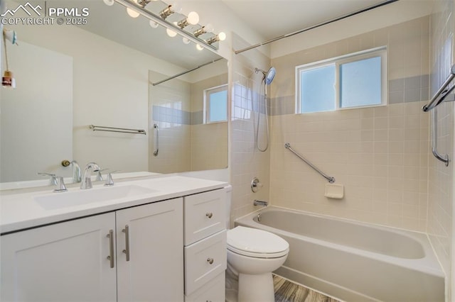 bathroom featuring vanity, toilet, wood finished floors, and shower / bathtub combination