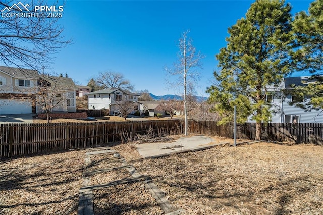 view of yard featuring a patio, fence, and a residential view