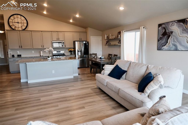 living room featuring recessed lighting, light wood-type flooring, and lofted ceiling