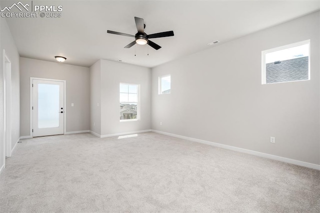 spare room with visible vents, baseboards, light colored carpet, and a ceiling fan