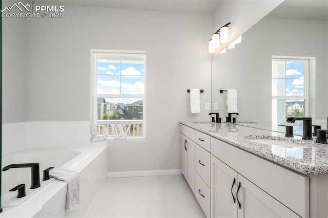 full bath with a bath, plenty of natural light, baseboards, and a sink