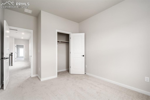 unfurnished bedroom featuring light carpet, visible vents, a closet, and baseboards