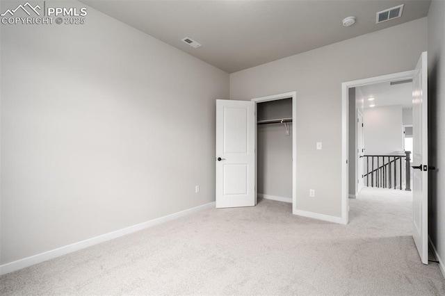 unfurnished bedroom featuring baseboards, visible vents, a closet, and light carpet