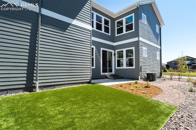 exterior space featuring central air condition unit, entry steps, a yard, and fence